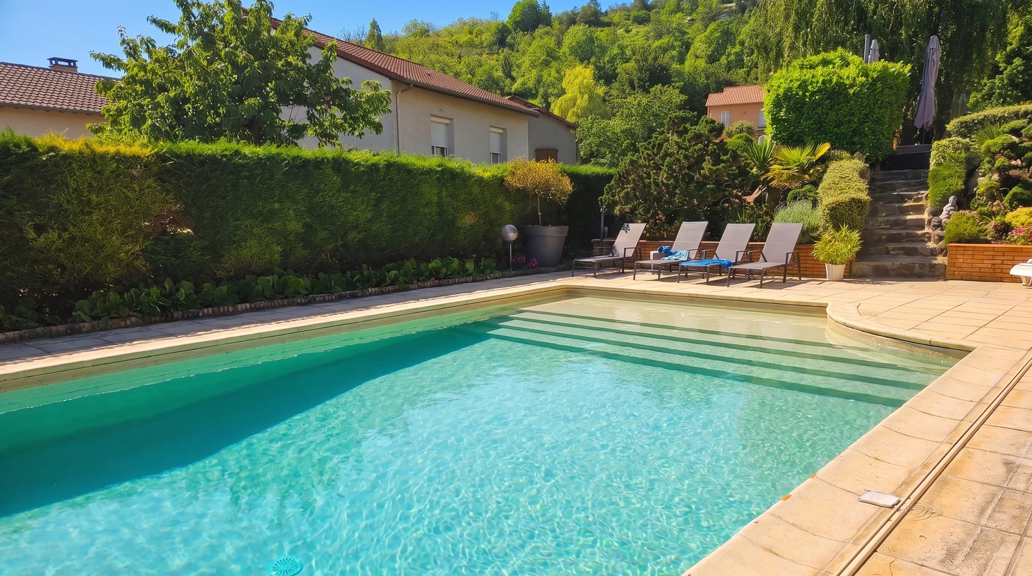 Espace extérieur contemporain avec piscine turquoise, terrasse en bois exotique IPE, transats design intégrés