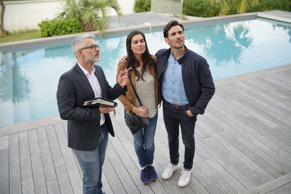 Piscine rectangulaire neuve en cours de remplissage, terrasse en bois composite IPE, liner gris clair, mains courantes inox